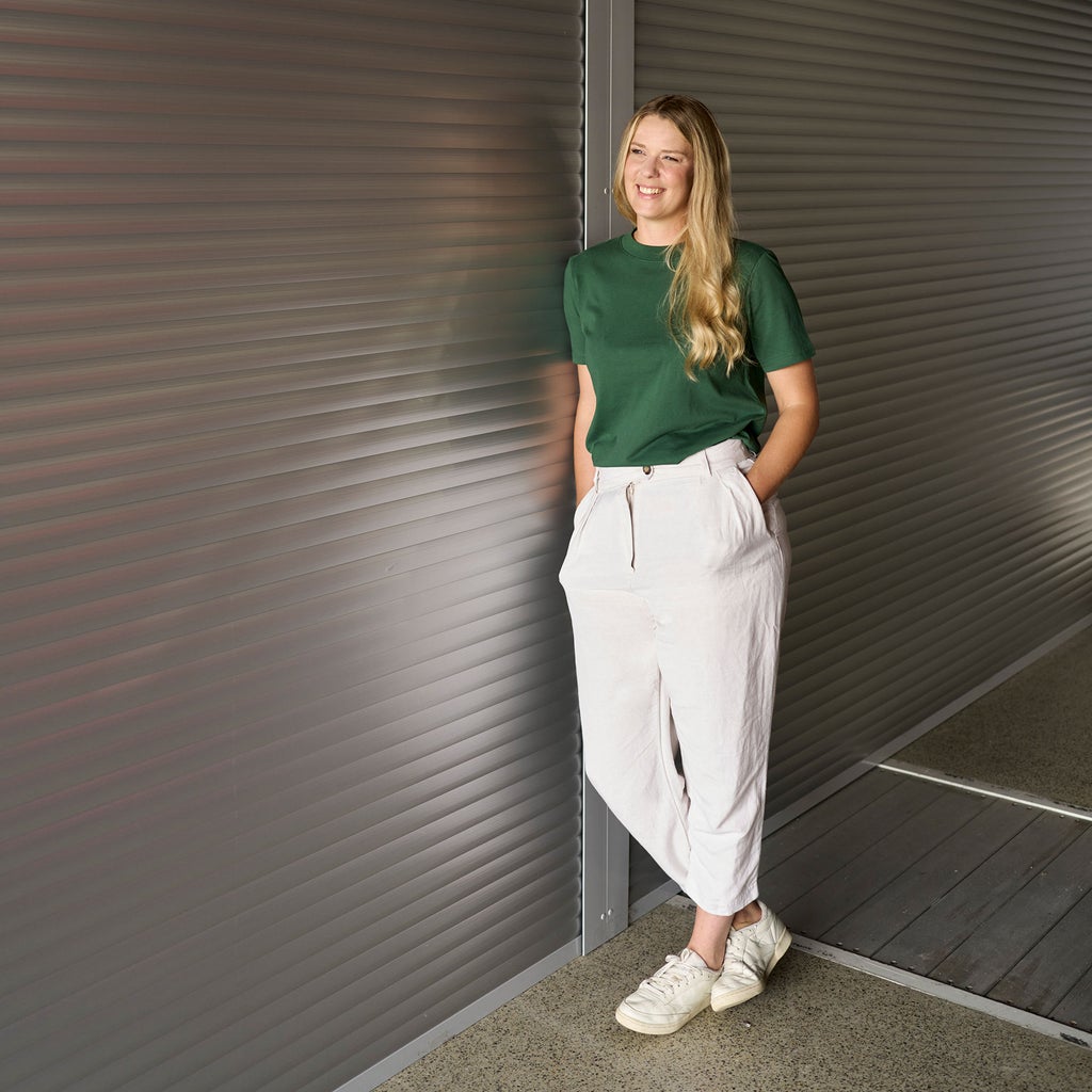 Lissi Lanz hat ihre Hände in den Hosentaschen und ist an eine Wand gelehnt