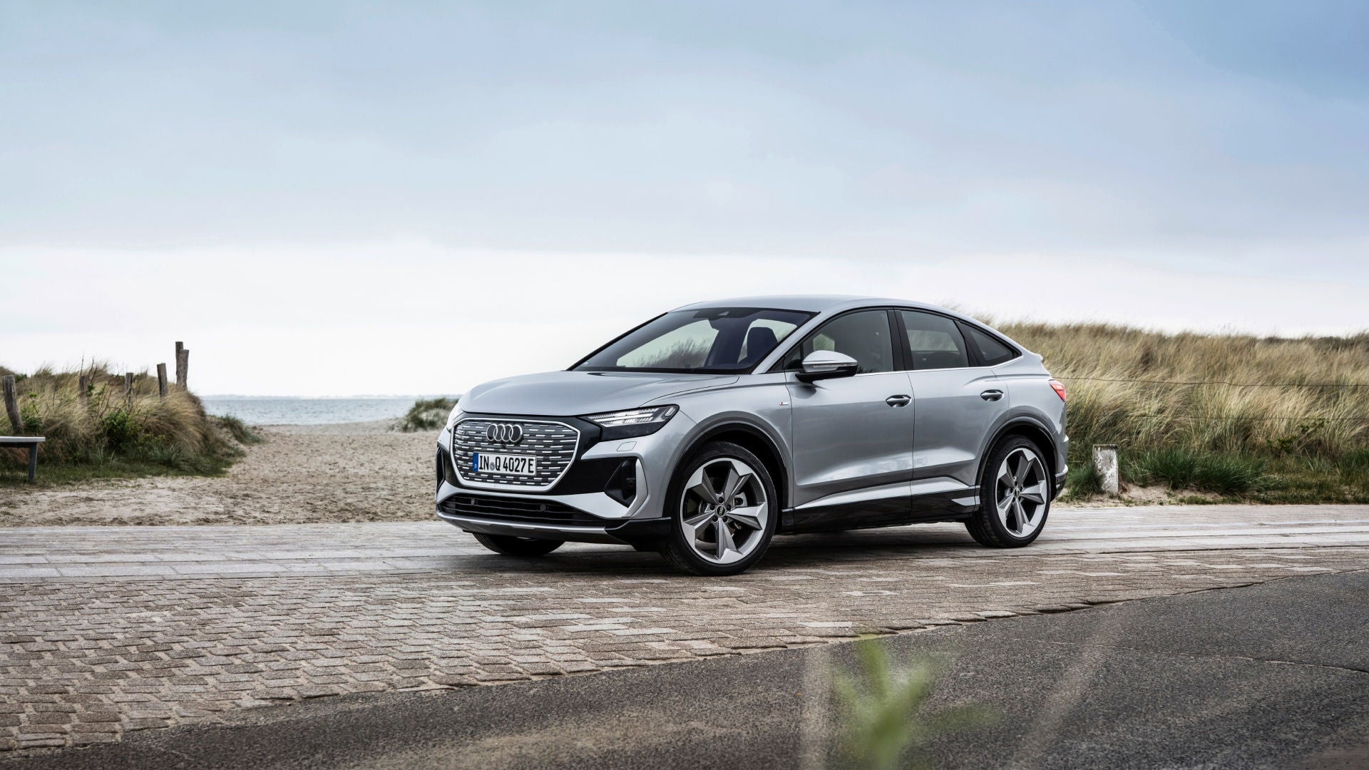 Ein Audi Q4 e-tron Sportback vor einer Strandkulisse. 