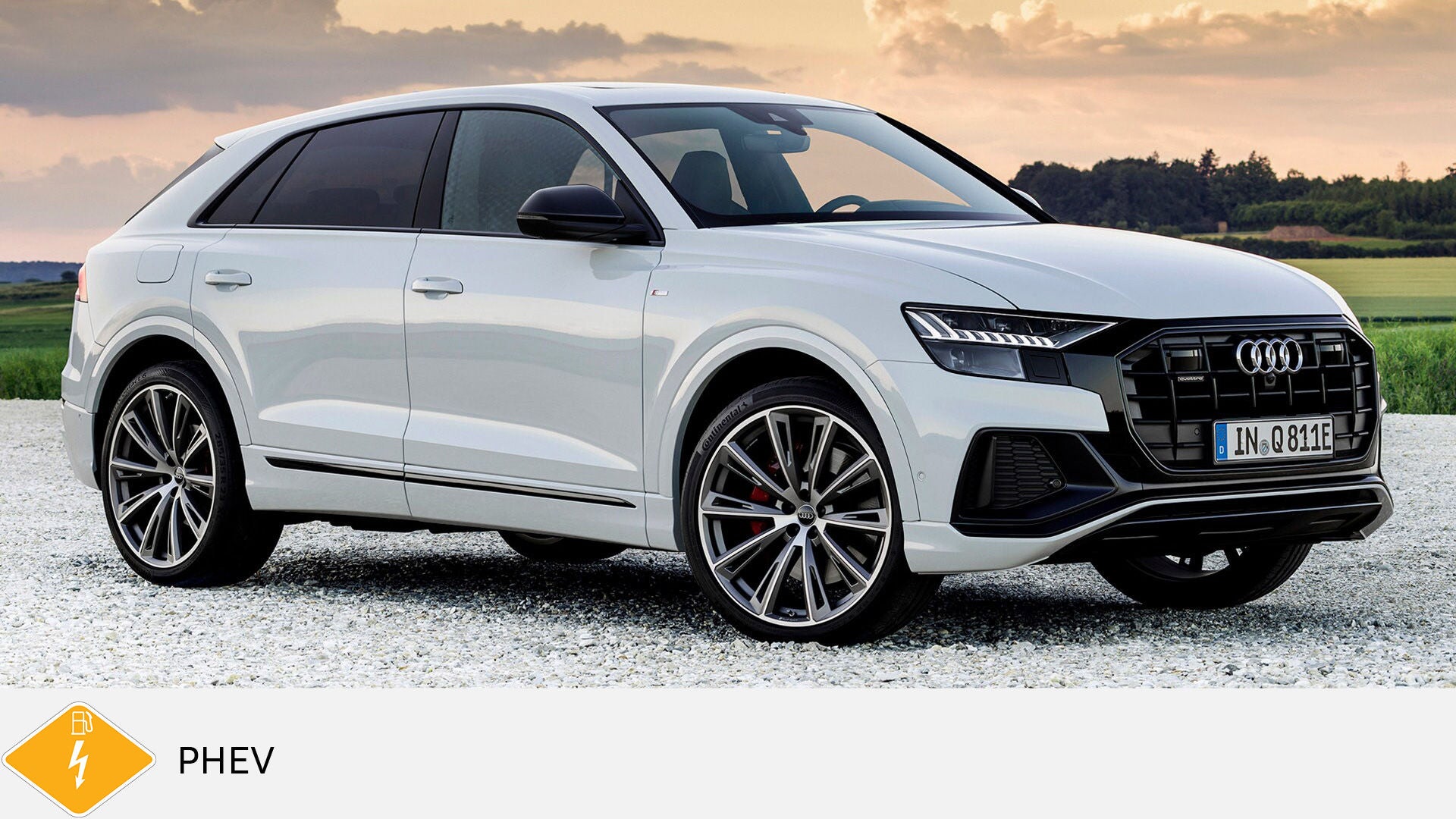 Weißer Audi Q8 TFSI e steht auf Kies vor Sonnenuntergang und Wiese. Unten gelbes PHEV-Symbol mit Zapfsäule und Blitz.