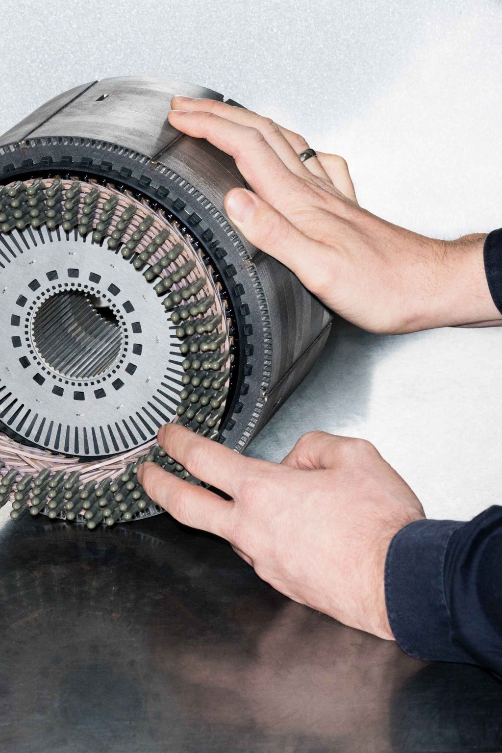 Die Hände von Bastian Heidler deuten auf Details eines E-Motors, der in aktuellen vollelektrischen Audi Modellen verbaut ist.