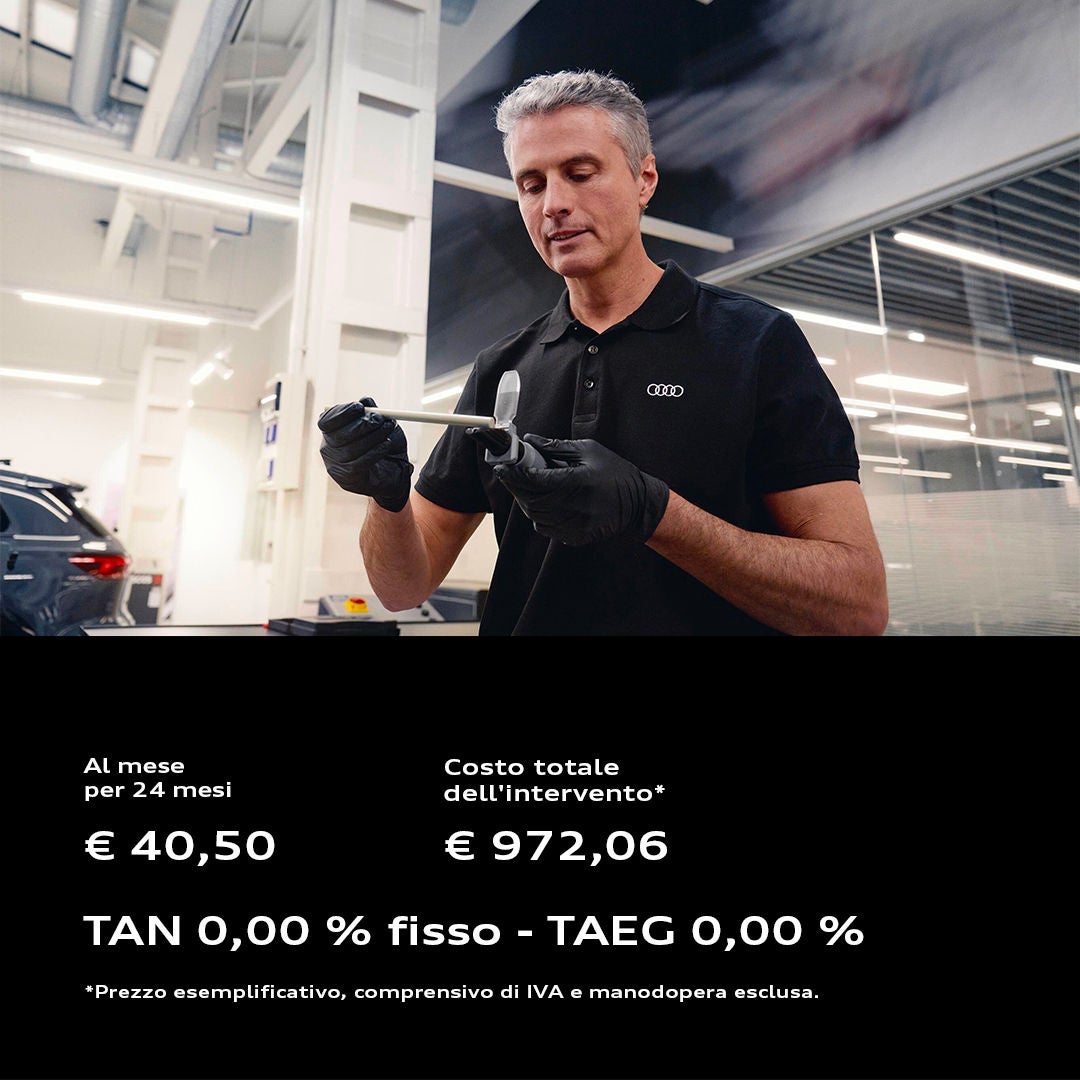 In officina un tecnico utilizza un avvitatore pneumatico per lavorare sulla ruota di un veicolo Audi.