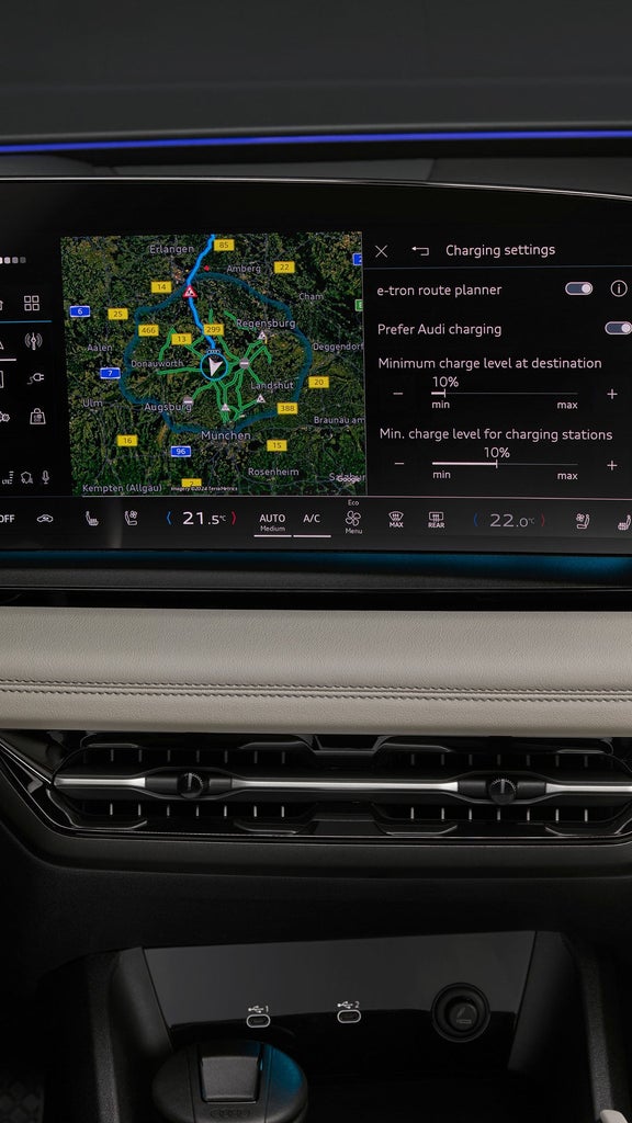 Interior view of an Audi vehicle with steering wheel, dashboard, and touchscreen display