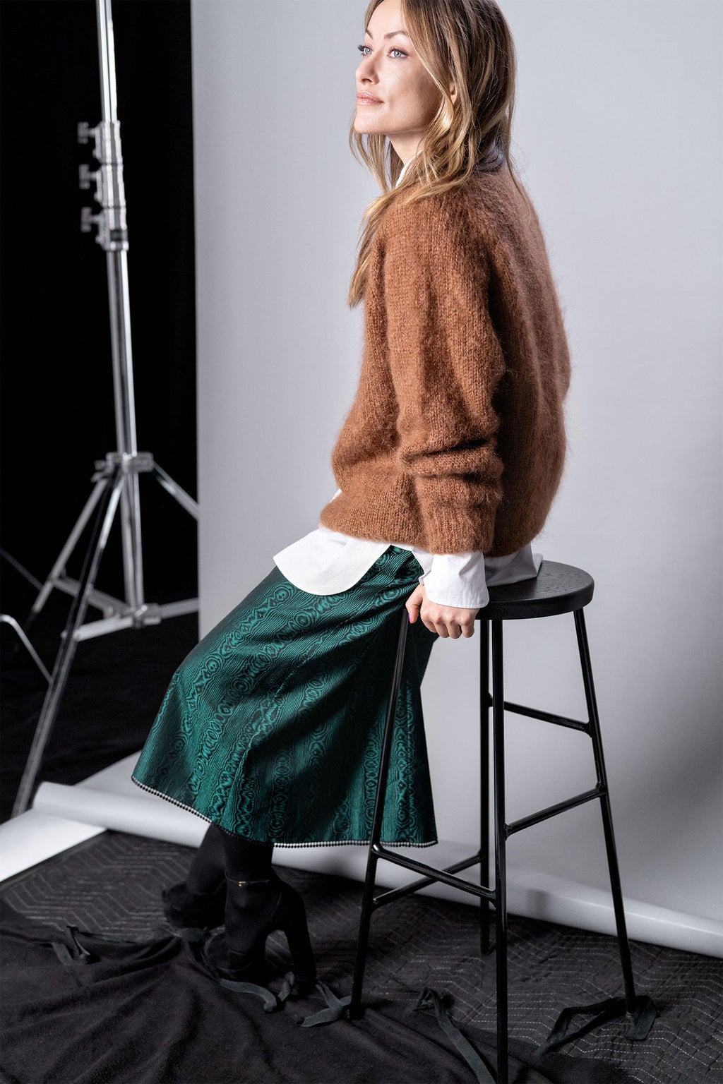 Olivia Wilde est assise sur une chaise noire.