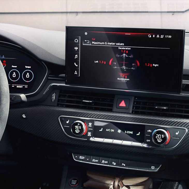 Audi car dashboard with digital displays showing vehicle performance metrics.