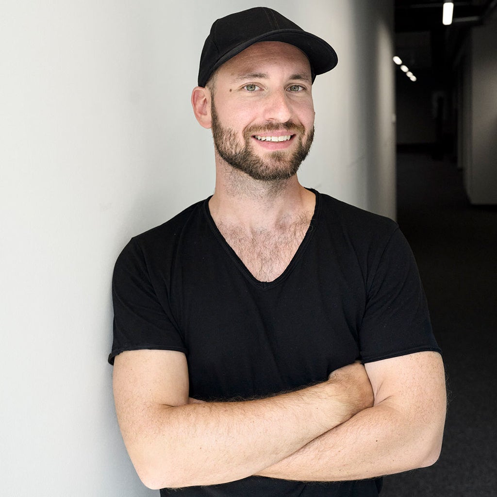 Sebastian Kister schaut in die Kamera und trägt ein schwarzes Shirt und Cap.