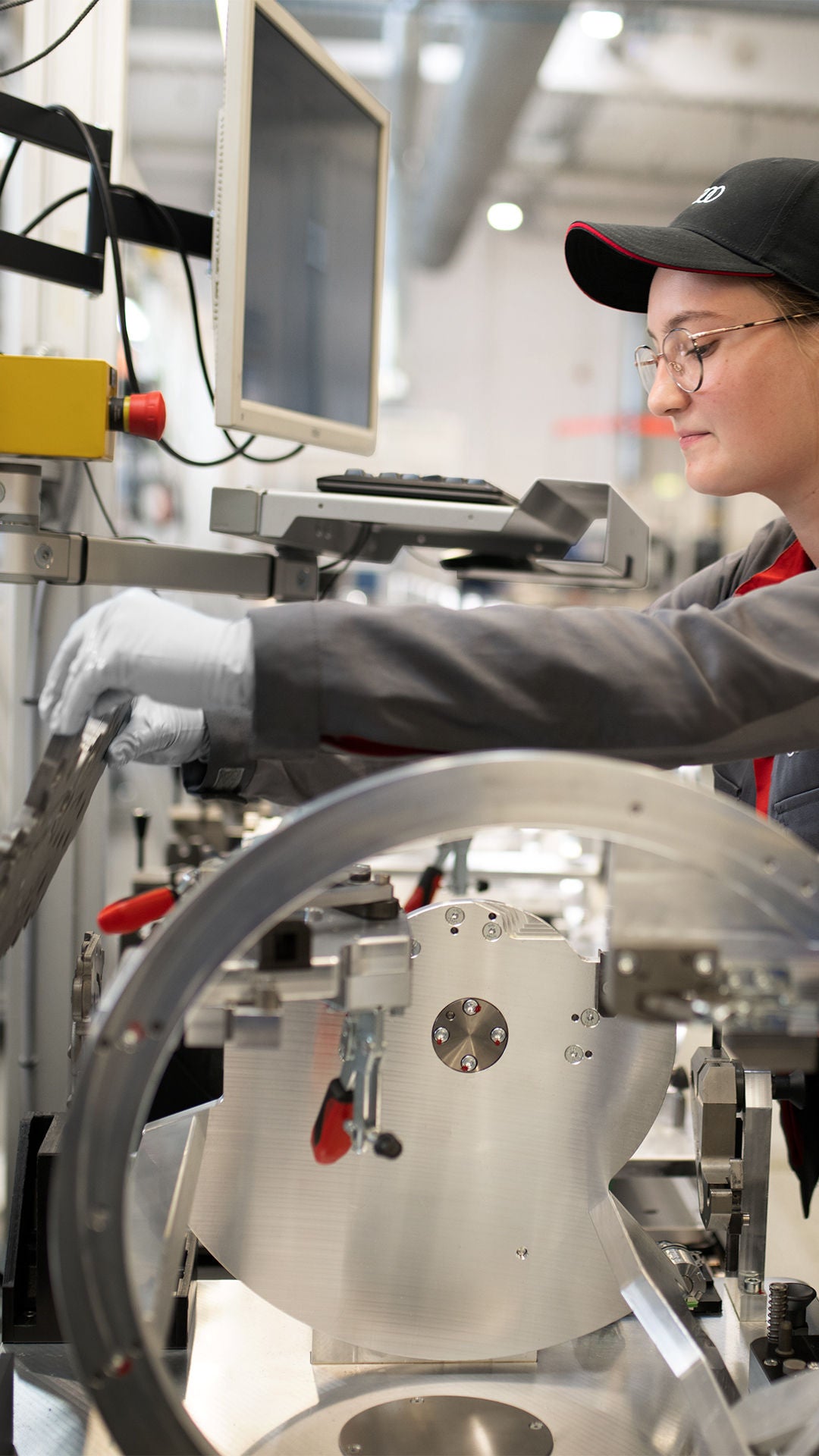 Primo piano di una donna che sottopone i ricambi ricondizionati Audi a test di qualità.         