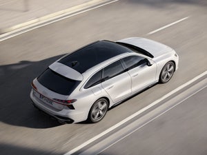 Een witte Audi A6 Avant e-hybrid op de snelweg.