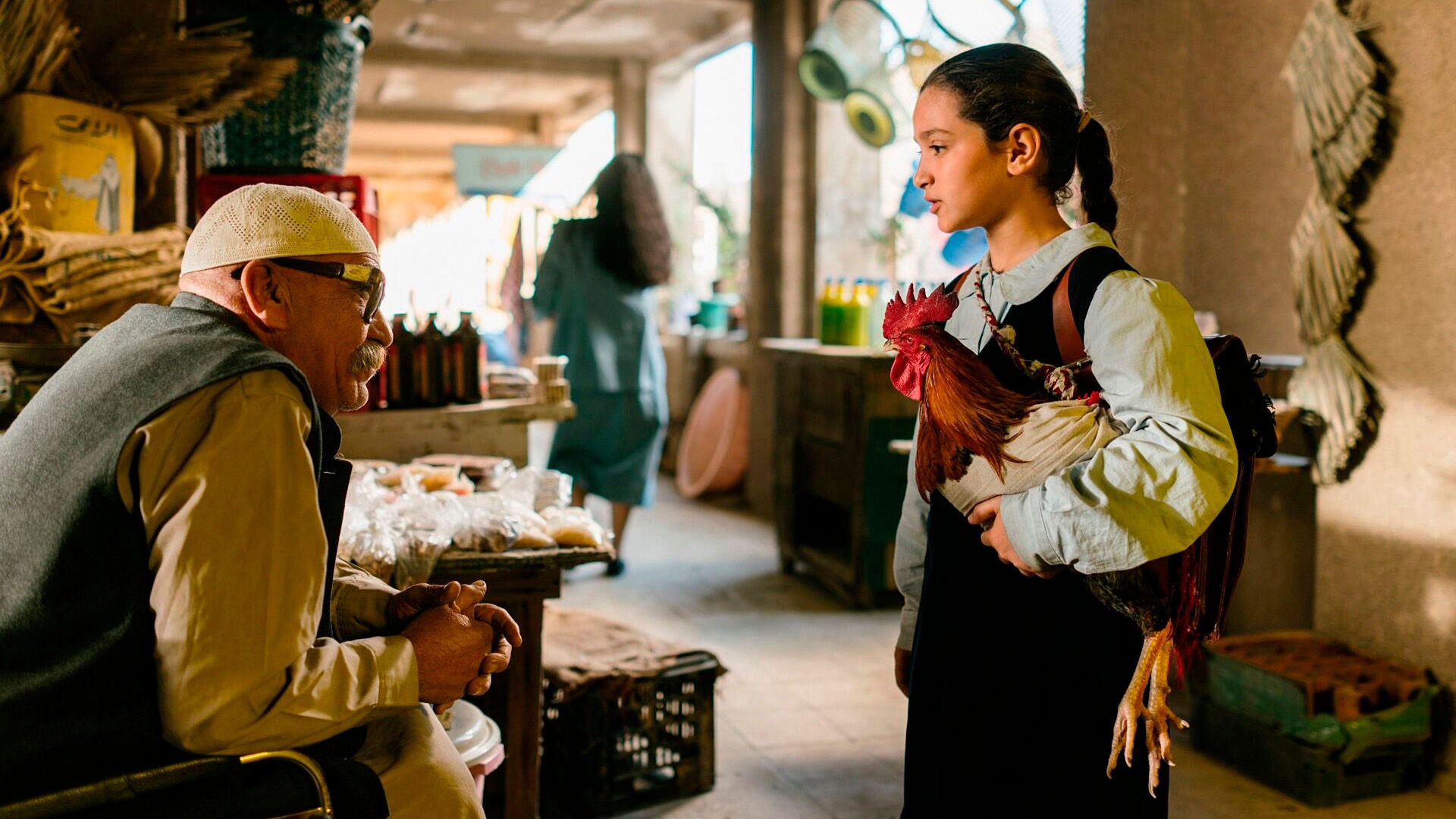 Die 9-jährige Lamia versucht auf dem Basar, mit einem Huhn unter dem Arm Lebensmittel zu tauschen.