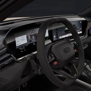 Blick auf das Cockpit der RS 5 Limousine von der Fahrerseite. Zu sehen sind das Lenkrad und die digitalen Displays.