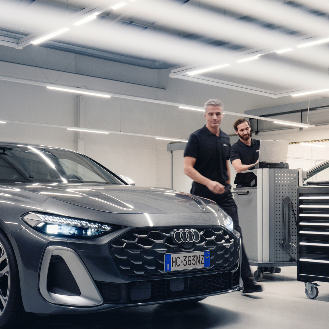 due addetti service Audi, ispezionano un auto