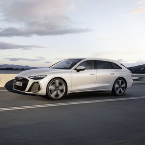 A6 Avant e-hybrid kör längs en väg vid en sjö.