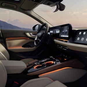 Blick in das Cockpit der A5 Limousine von der Beifahrerseite. Der Innenraum erscheint dabei in orangenem Ambiente Licht.