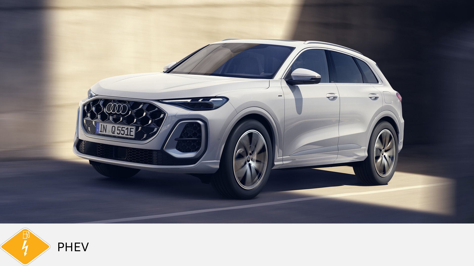 White Audi Q5 plug-in hybrid driving through a sunlit urban setting, PHEV icon in bottom left corner.