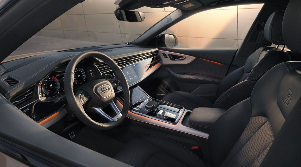 Blick ins Fahrerfenster des Q8 SUV auf das Cockpit und die vorderen Sitze.