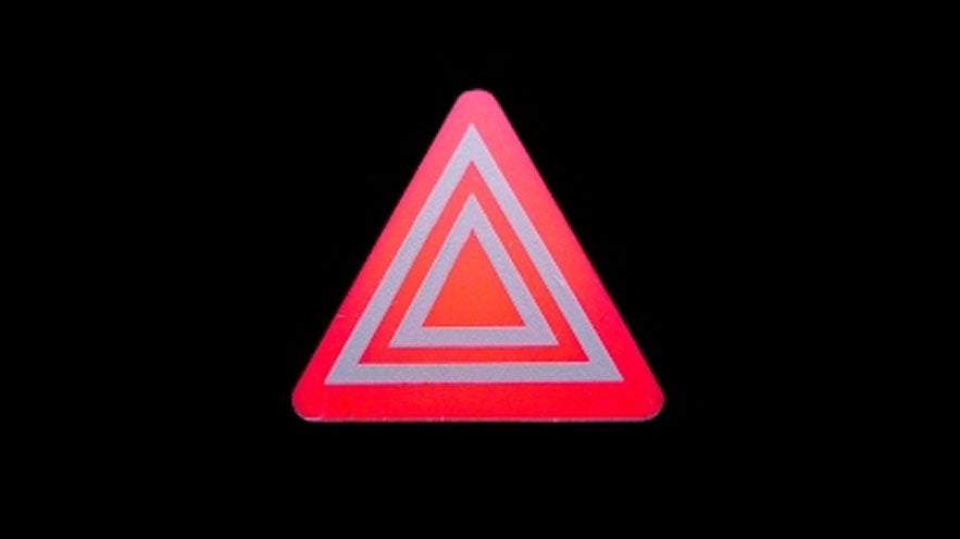Rotes Warnblinkersymbol in Dreiecksform auf schwarzem Hintergrund, zeigt Fahrzeuggefahr oder Panne an.