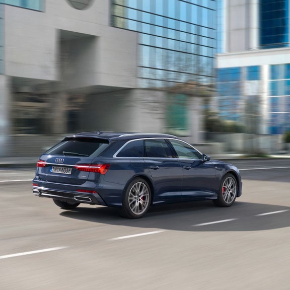 A blue car driving on a city street, exhibiting motion blur.