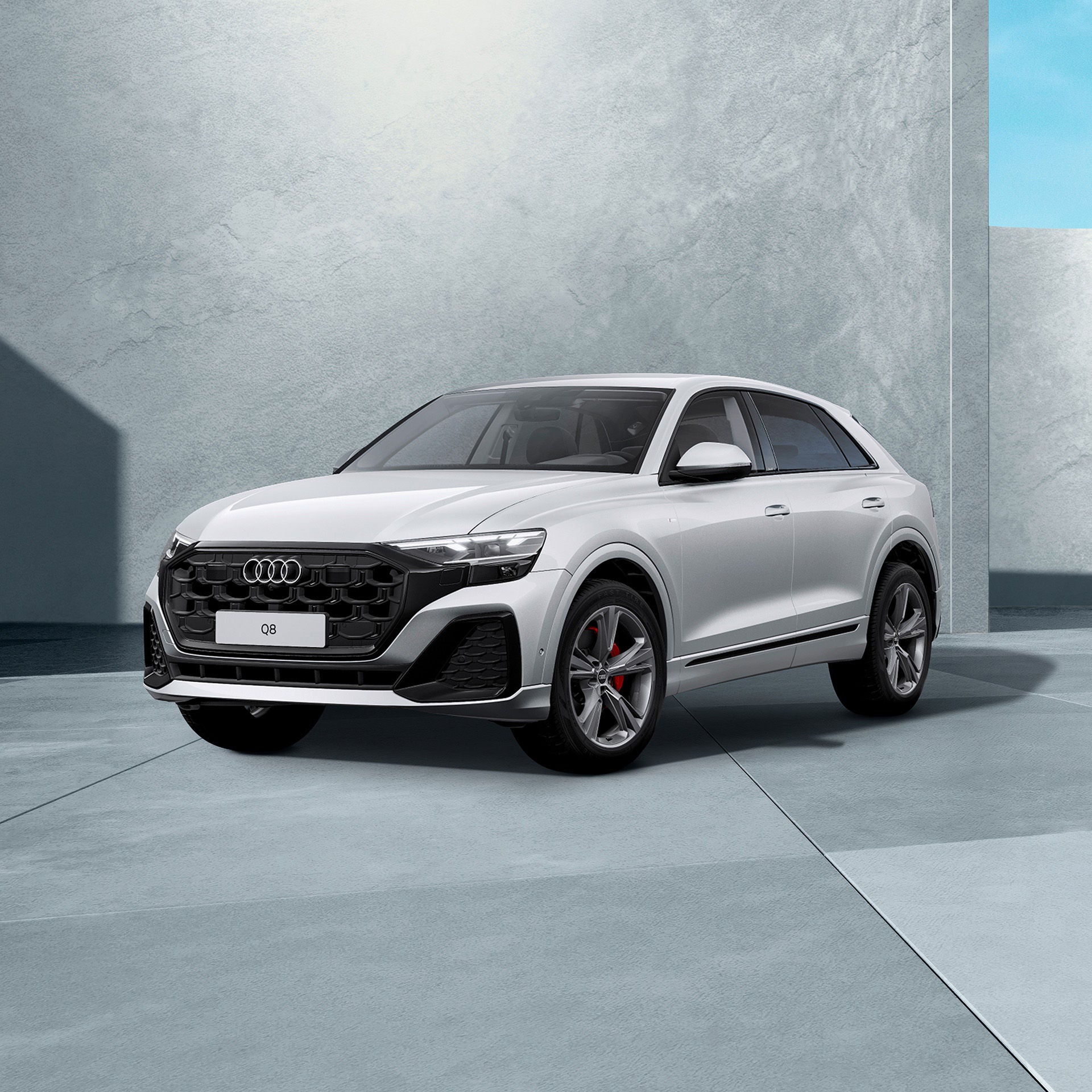 Ein weißer Audi Q8 SUV von schräg vorne fotografiert vor einer modernen Kulisse.