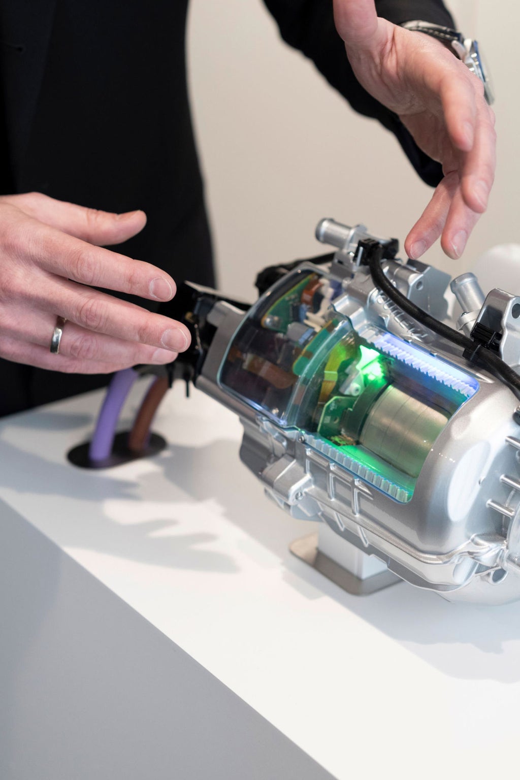 Die Hände von Matthias Honzne gestikulieren an einem Modell eines Treibstranggenerators.