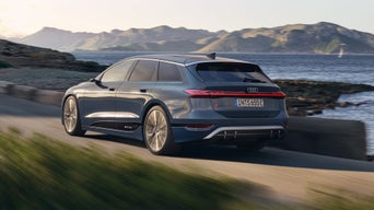 Der S6 Avant e-tron aus schräger Heckansicht fährt durch kurvige Straßen mitten in der Natur. Im Hintergrund sind Bäume und Berge zu sehen.
