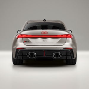 De achterkant van de Audi RS 5, waarbij de lavarode Audi-ringen duidelijk zichtbaar zijn.