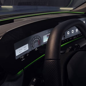 Blick durch das Fahrerfenster in das Cockpit des Q5 SUV. Im Fokus ist das grüne Interaktionslicht am unteren Rand der Windschutzscheibe.