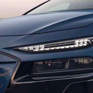 Close-up of the Matrix LED headlights on a metallic blue Audi vehicle. The sharp, angular design highlights the car's contemporary and sophisticated style.