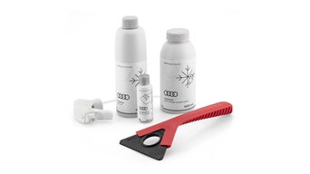 Audi Winterpflege-Set mit Enteiser, Glaspolitur, Frostschutz und Eiskratzer im Schnee.