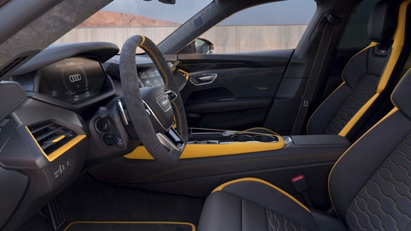 Car interior with black and yellow leather seats, steering wheel, and modern dashboard.