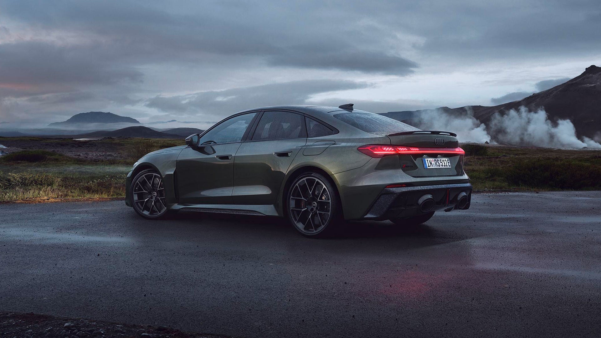 The all-new Audi RS 5 Sedan parked with mountains in the background.