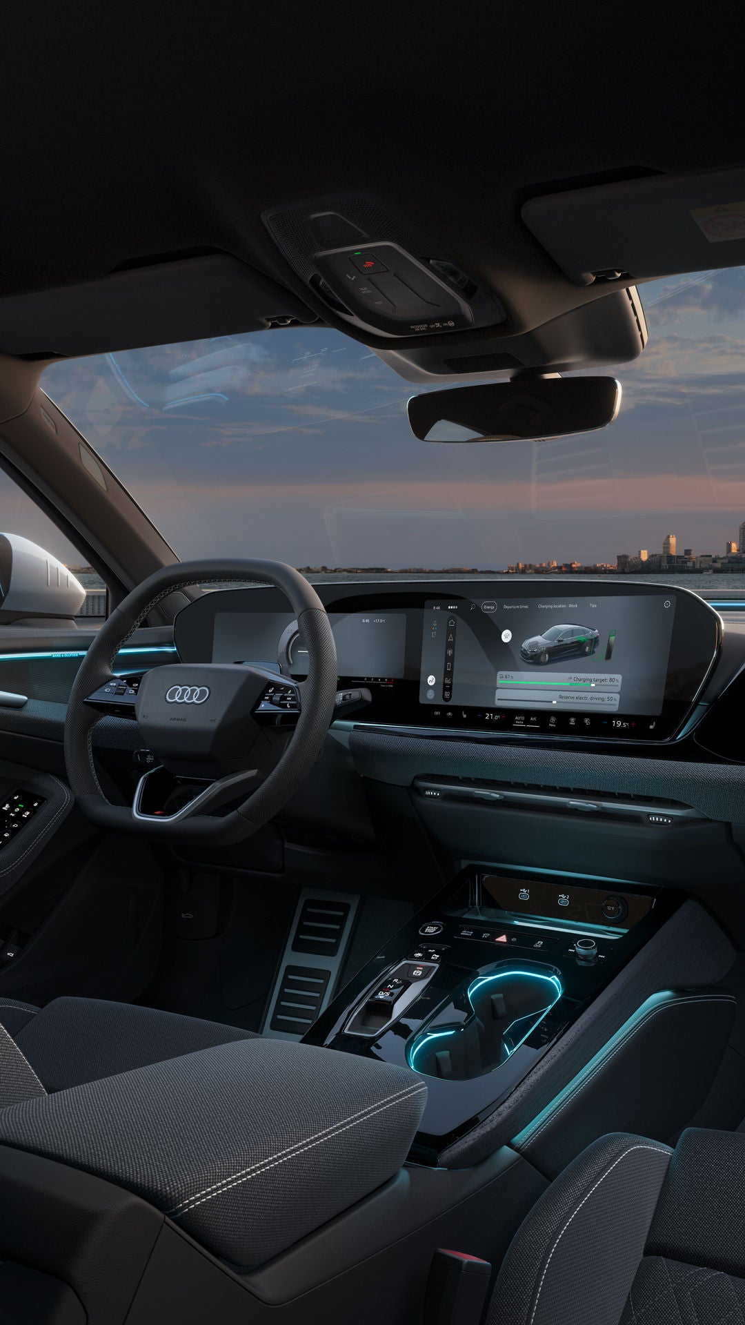Zicht vanaf de achterbank op de cockpit van de Audi A5 Berline e-hybrid. Onder meer de MMI-touchdisplays, de sfeerverlichting en de interactieverlichting zijn zichtbaar. Op de achtergrond is de skyline van een stad te zien.