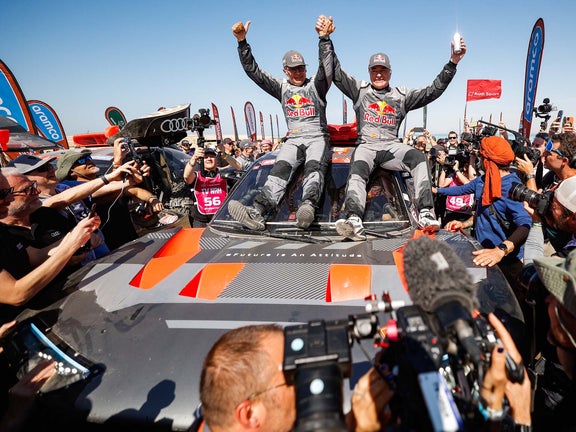 A picture showing Carlos Sainz and Lucas Cruz celebrating their 2024 Dakar Rally victory.