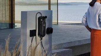 An EV charger mounted on an outside white wall