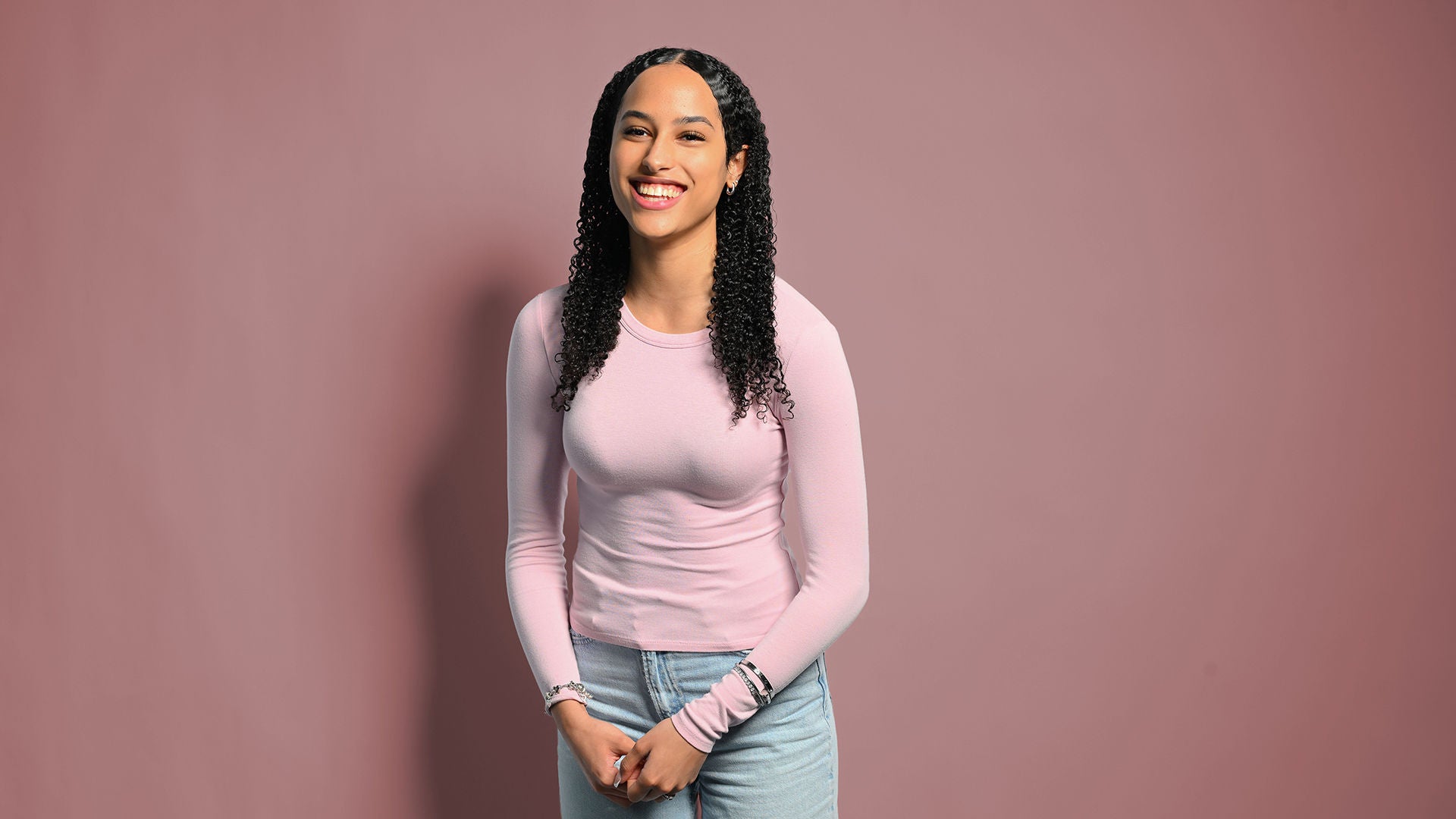 Lisa-Marie lacht in die Kamera und hält ihre Hände im Schoß