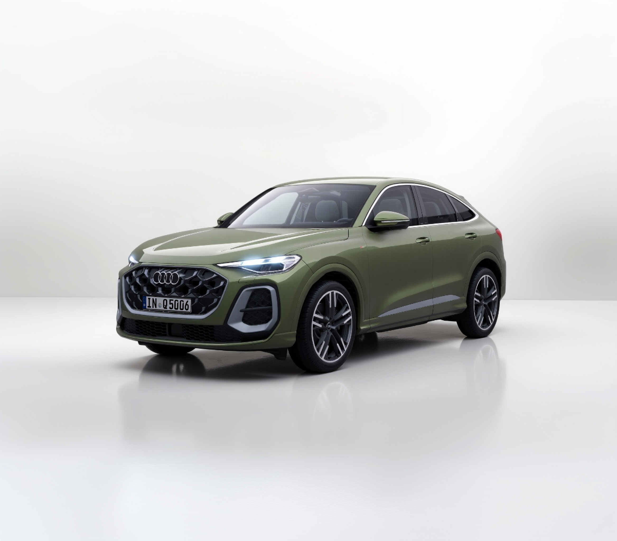 Ein olivgrünes SUV-Coupé steht in einem hellen Studio mit reflektierendem Boden und sanfter Beleuchtung.