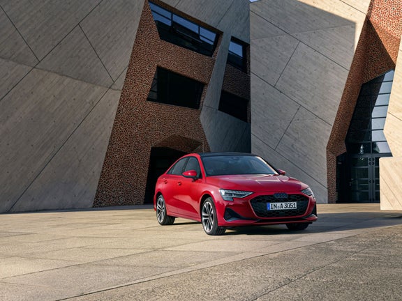 Ein roter Audi A3 Limousine steht vor einem modernen Gebäude