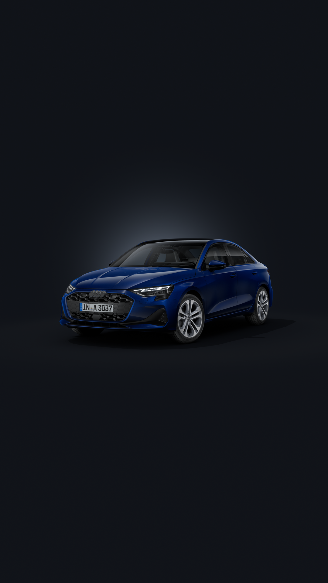 The Audi A3 saloon, viewed from an angle from the front against a dark background.