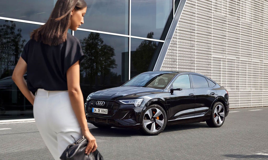 Woman approaching electric vehicle.