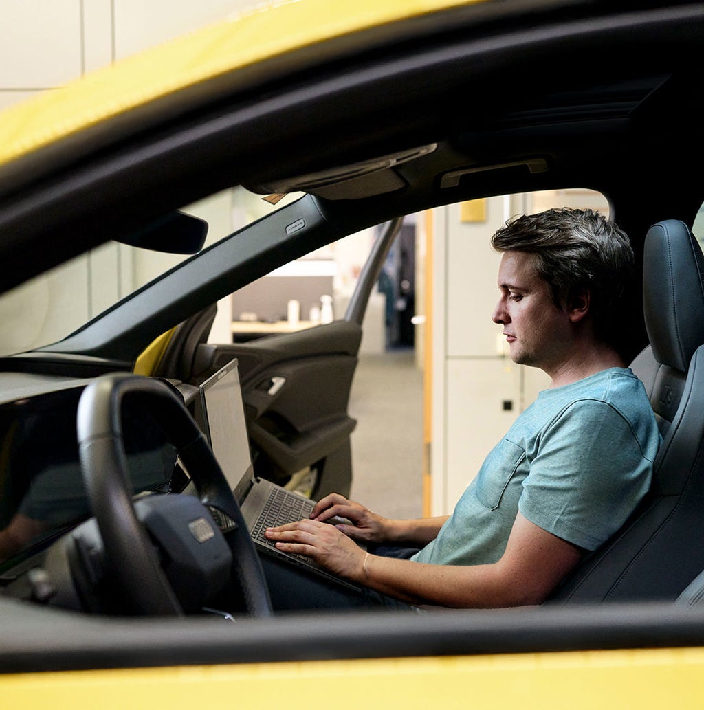 Jan Totz is sitting in the passenger seat of an Audi, looking at the laptop on his lap