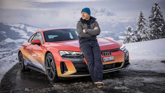 Didier Cuche stehend vor einem Audi e-tron GT  