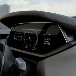 Close-up of the digital cockpit of an Audi S e-tron GT, featuring a speedometer, battery status indicator, and date/time display. The display shows a remaining range of 425 km and is playing the song “Purple Rain.”