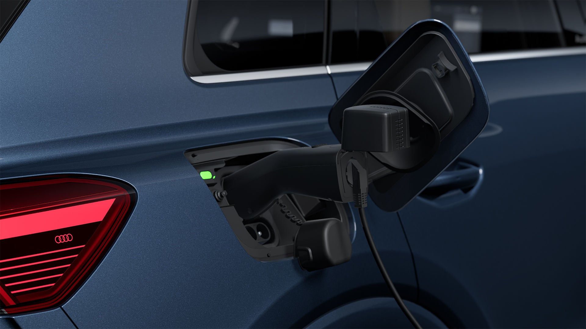 Une Audi Q4 e-tron dont le bouchon du réservoir est ouvert et dans lequel se trouve un adaptateur de recharge