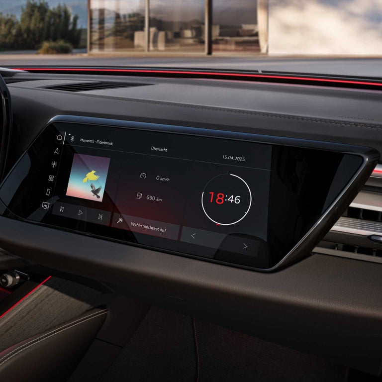 Detailaufnahme eines digitalen Fahrzeugdisplays mit Uhrzeit, Geschwindigkeit und Musiktitel.
