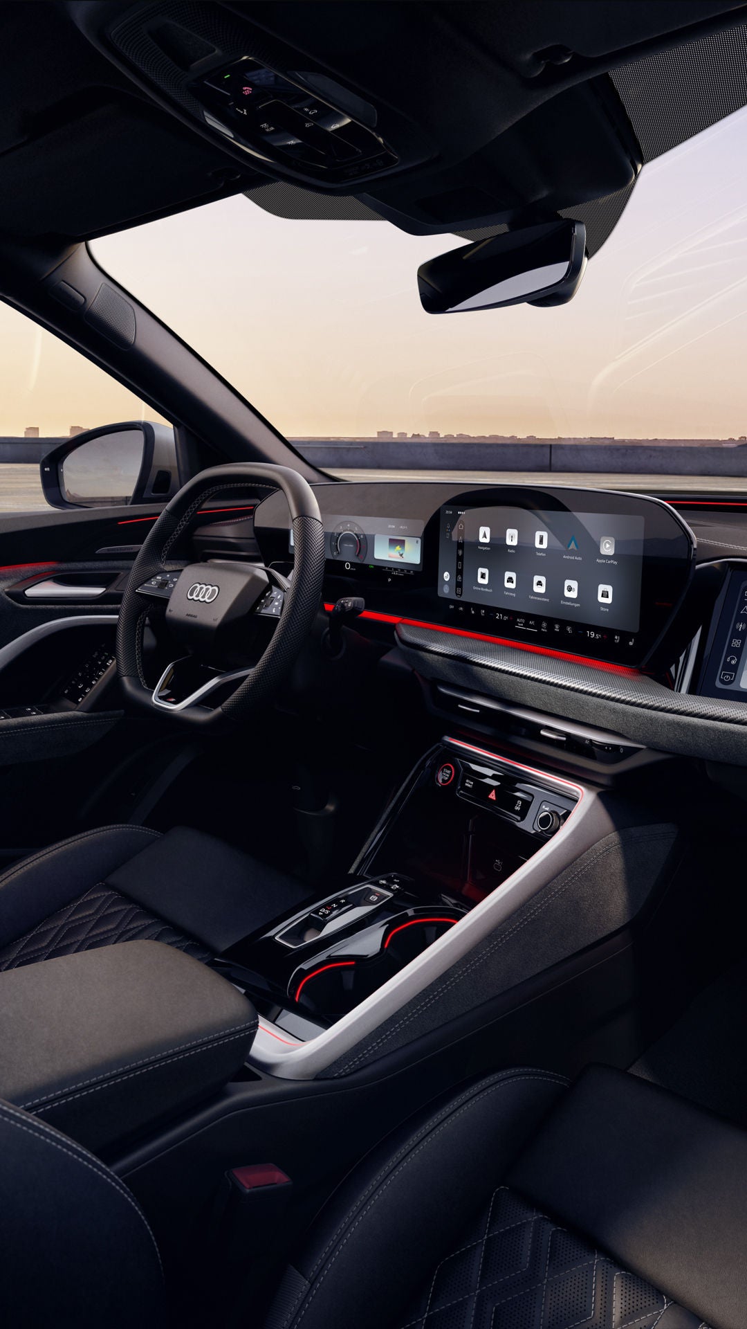 Blick durch das Beifahrerfenster in das Cockpit des SQ5 SUV. Zu sehen sind unter anderem das Panoramadisplay, das MMI Beifahrerdisplay, sowie die rote Ambiente Beleuchtung.