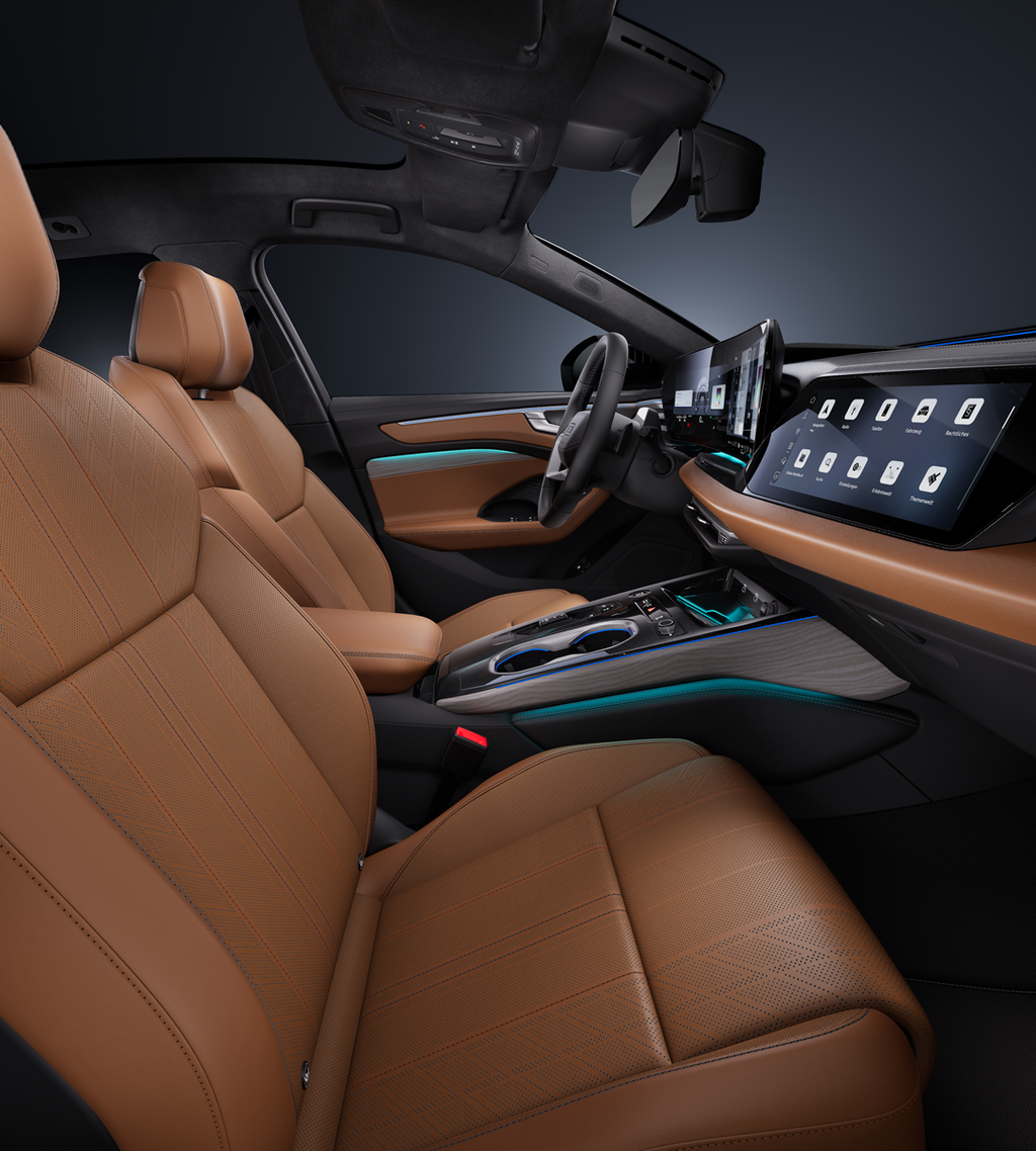 View from the passenger side of the cockpit, showing the steering wheel, centre console, digital displays, ambient lighting and the seats.