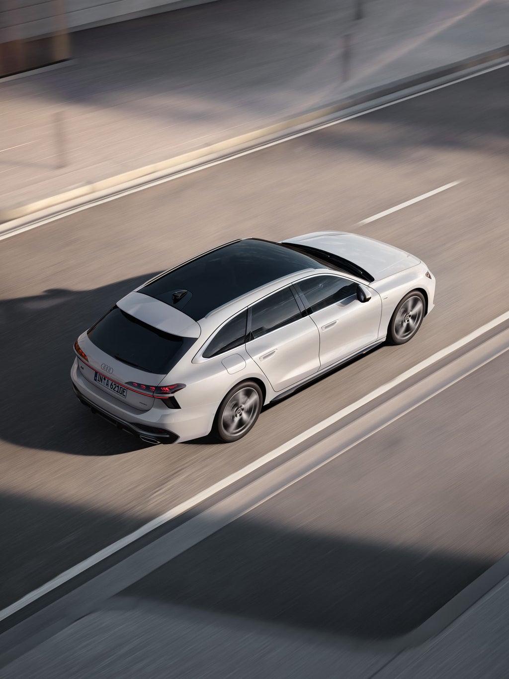 Audi A6 Avant e-hybrid kör på en väg, sedd ovanifrån.