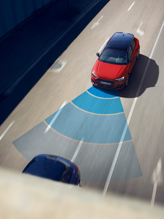 Roter Audi A1 Sportback auf Straße mit visualisiertem blauen Sensorbereich des Fahrassistenzsystems nach vorn.