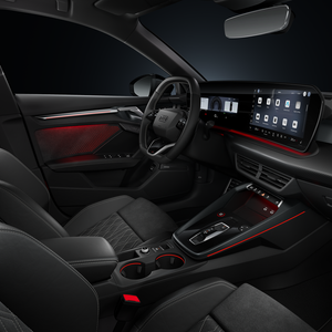 Blick von der Beifahrerseite auf das Cockpit mit Lenkrad, Mittelkonsole, digitale Displays und das Ambiente-Licht.