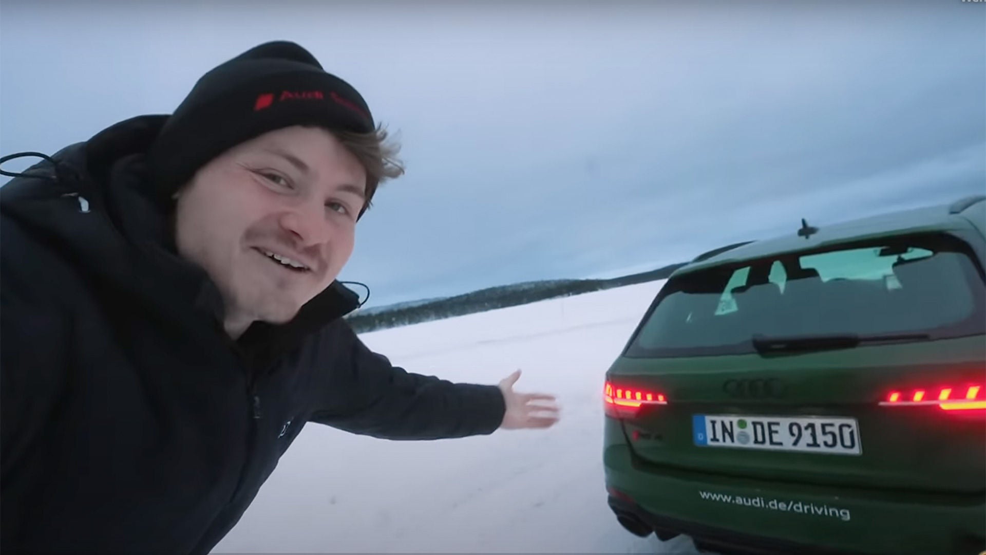 Youtuber Felix von der Laden steht vor einem dunkelgrünen Audi Modell im Schnee bei der Audi ice experience in Finnland.