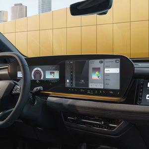 The cockpit and panoramic display as seen from the passenger's perspective. The interior is bathed in sunny yellow ambient lighting.