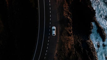 Audi A6 Sportback e-tron performance auf einer Landstraße am Wasser